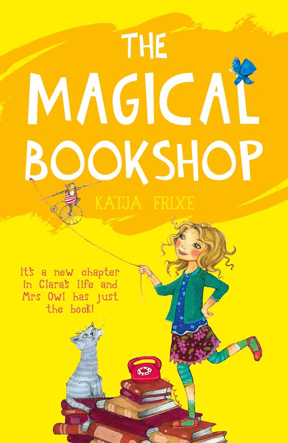 A yellow book with a grey cat, a stack of books , a teapot and a blonde haired girl under the title The Magical Bookshop by Katja Frixe