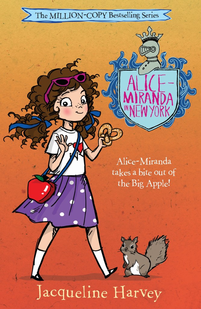Alice-Miranda in New York

An orange cover with a brown-haired girl in a purple skirt with white spots, a white t-shirt and red bag.  There is a squirrel next to her. A blue shield with pink text is at the top. Pink text says Alice-Miranda in New York by Jacqueline Harvey. 
