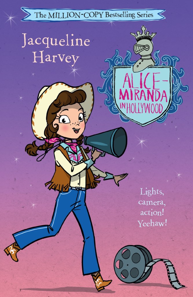 Alice-Miranda in Hollywood

A pink and purple cover with a brown-haired girl in a white shirt, a tasselled waistcoat and jeans, holding a megaphone. There is a movie film reel next to her. A blue shield with pink text is at the top. Pink text says Alice-Miranda in Hollywood by Jacqueline Harvey.

